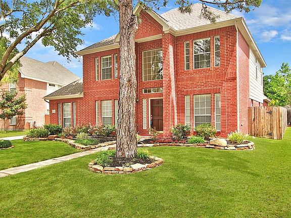 Professionally landscaped yard featuring a sprinkler system in the front and back.