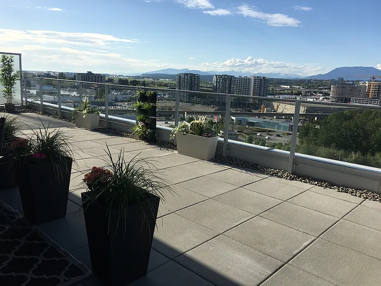 Private terrace with panoramic views of North Shore mountains and water views of the Fraser River.