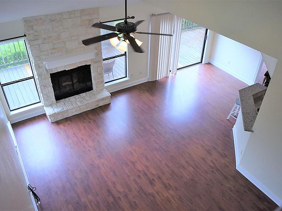 View of living room from balcony showing fireplace and back deck.