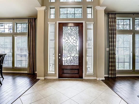 On either side of this beautiful leaded glass door are both a Formal Dining and Living Rooms with matching tall windows and hardwood floors.