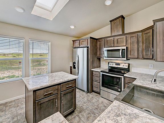 Kitchen - Solid wood cabinets, stainless appliance package, upgraded nickel hardware, center island, title back splashes, country farm sink with pull out faucet, skylight, recessed lighting.