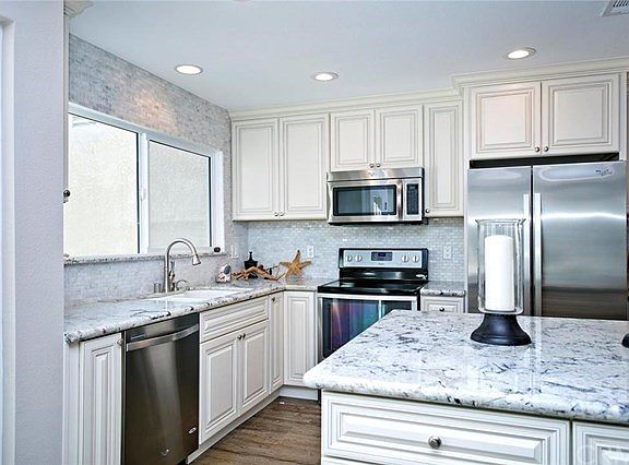 Kitchen features granite counters, stainless appliances & creme glazed cabinetry.