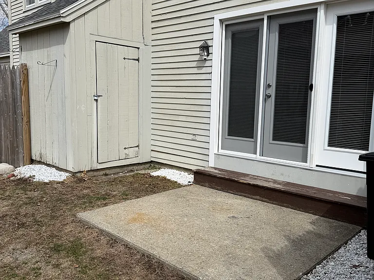 A small patio in the back with a little storage