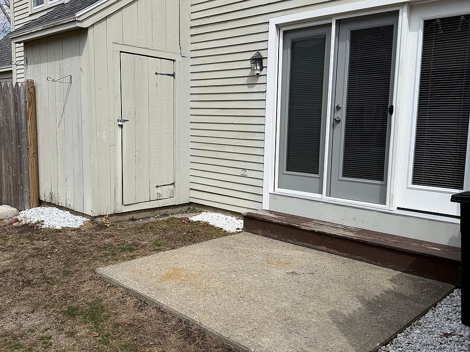 A small patio in the back with a little storage