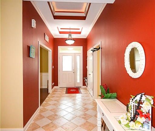 Tray ceilings in entry way with beautiful and welcoming ceramic tile.