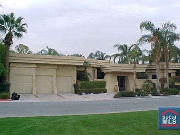 Front of home with 3-car garage and circular driveway.