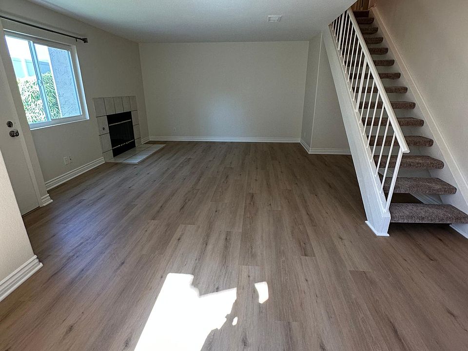 View of Living Room and Fireplace. Carpeted stairs to second floor