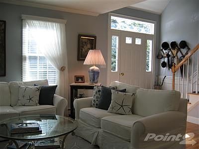 View of living room looking towards main entrance to house. Ceiling is cathedral over door. All ligh