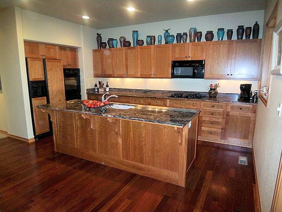 Galley Style Kitchen with Cherry Cabinets and Granite Counters