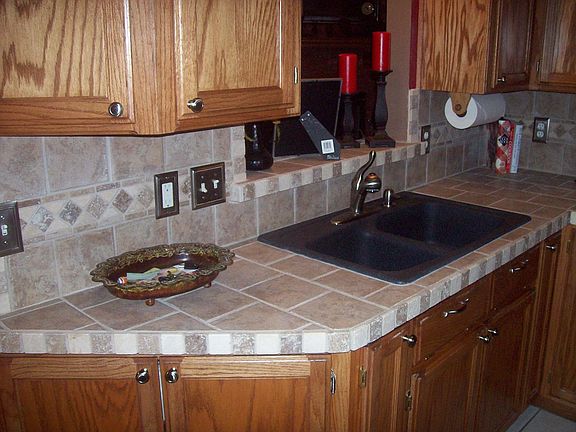new granite sink with satin nickel faucet and all new hardware on the cabinets