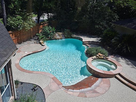 Look at this private OASIS Backyard space! Large beach entry pool with steps down, a raised spa, rock waterfall with diving rock! Lots of mature landscaping. There is a shed behind the garage for extra storage.