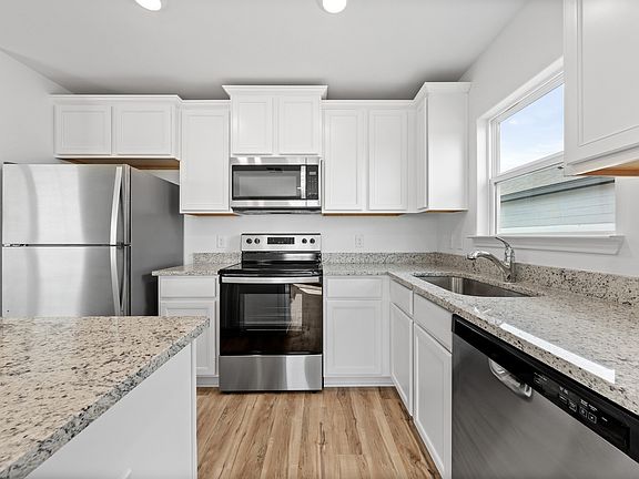 Granite countertops and stainless steel appliances fill the kitchen