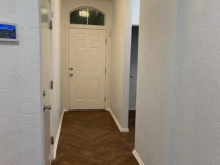 Front Door view from inside. Opening leads to bedrooms two and three plus full bath
