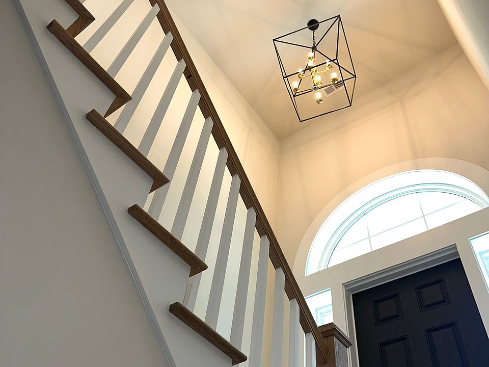 When you enter through the front door you're met with a stunning hardwood staircase and an overhead light fixture.