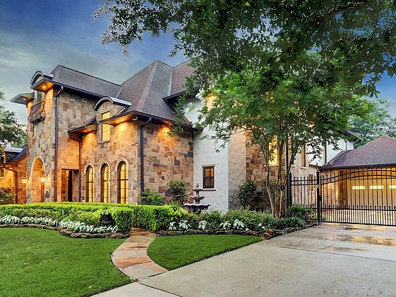 Exterior Facade: Flagstone/stucco on this elegant traditional with extra wide driveway, stone path to entry, pristine landscape and parking court behind driveway gate.