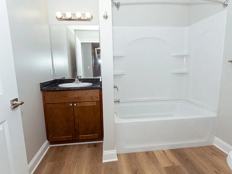 Another view of bathroom layout. Features curved curtain rod and tub surround shower.