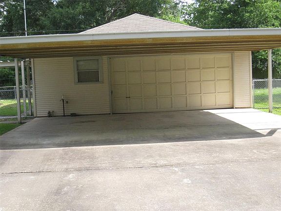 THREE CAR WIDE LARGE COVERED CAR PORT , GARAGE HAS GARAGE DOOR OPENER