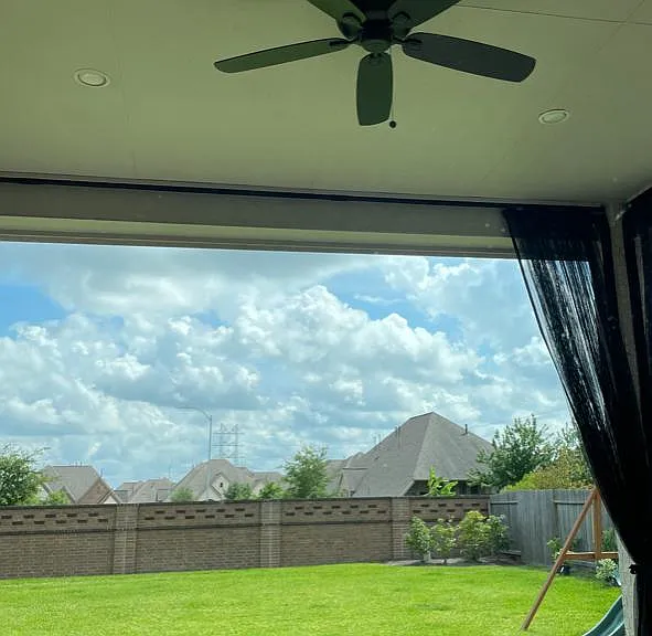 Covered patio with mosquito nets and an outdoor fan.