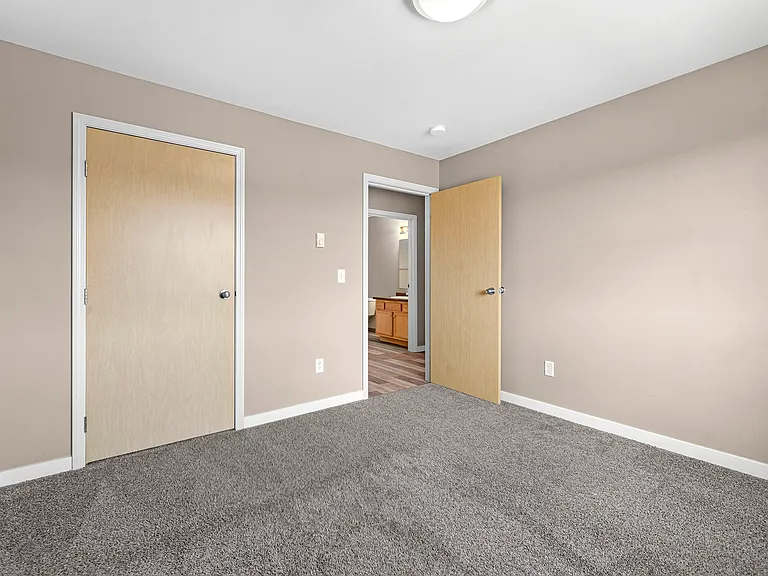 Step into comfort at Minot Place Apartments. This spacious room features soft carpeting and natural light, perfect for your personal touch. With easy access to modern amenities, this could be your new sanctuary. Schedule a tour today!