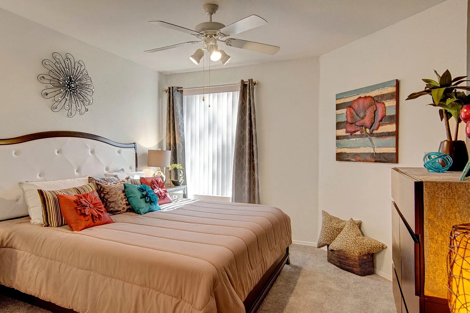 Luxurious bedroom with a king-size bed, plush bedding, decorative pillows, and a ceiling fan.