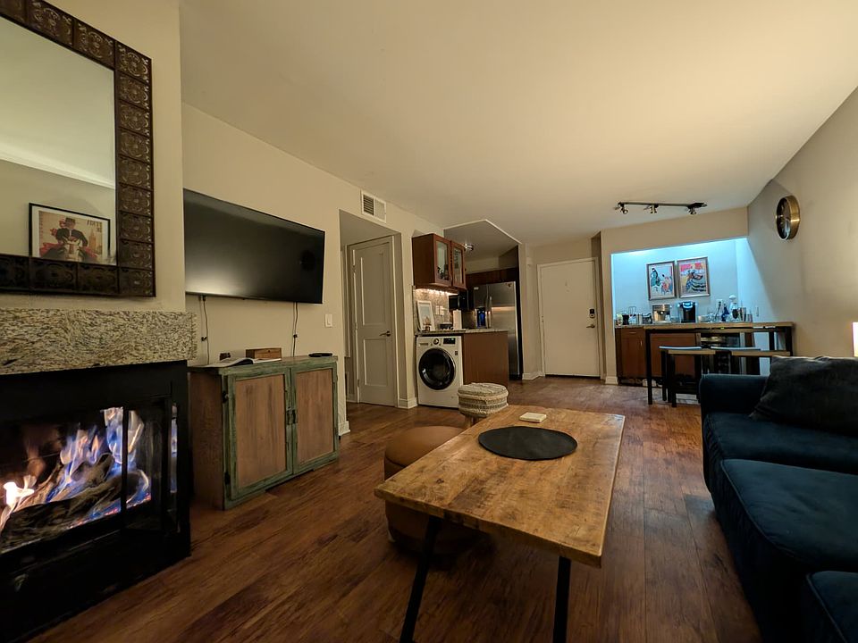 Hardwood floor. Fireplace , Thai wood coffee table , washer & dryer combo.