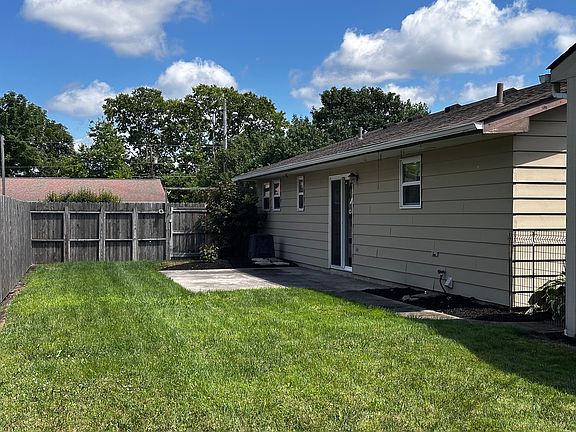 Privacy fenced backyard with a stamped concrete patio.