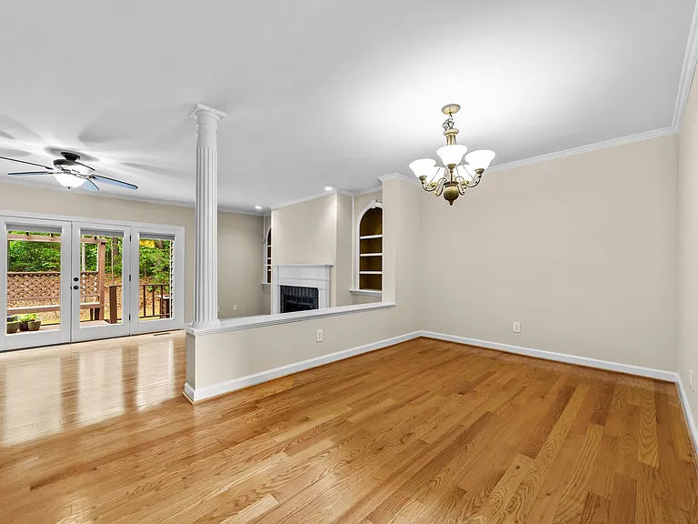 Open dining area with hardwood floors, chandelier, and easy flow into the living room.
