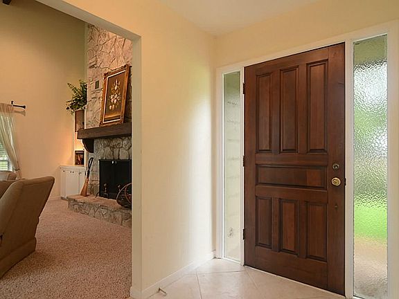 A Grand Entry welcomes your guests, & hardwood door is tastefully flanked with diffused side lights.   Notice the rich 20" porcelain tile, laid on diagonal. Around the corner, we get a peek at the majestic,  20' tall, fireplace