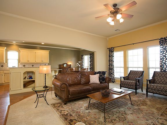 Open and airy Family Room is accented by custom paint, crown moulding, luxurious carpet and a wall of windows with 2" privacy blinds.