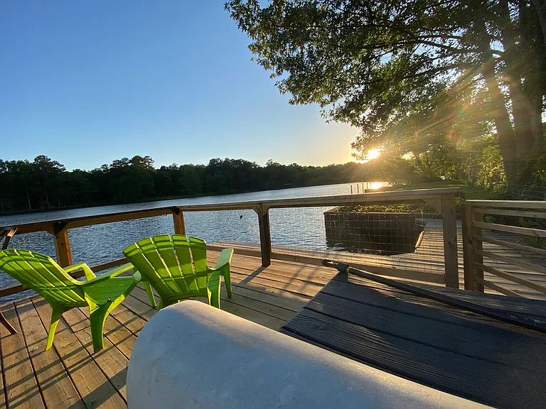 Dock with boat slip, storage box, under-rail lighting, seating, and sunset views.