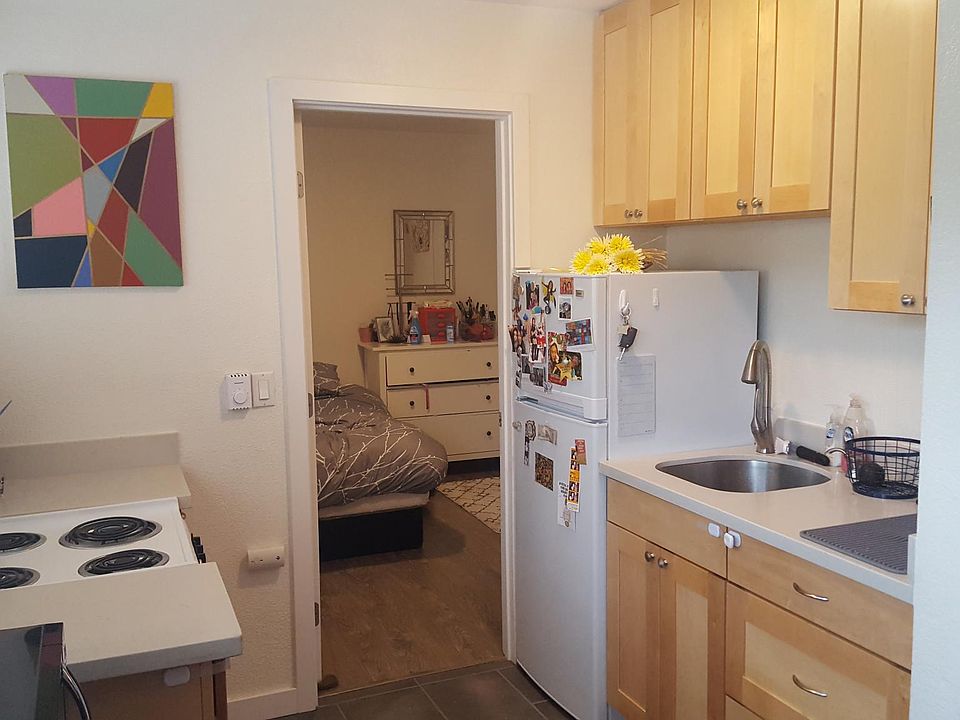 Light bright kitchen with maple cabinets and tile floor.