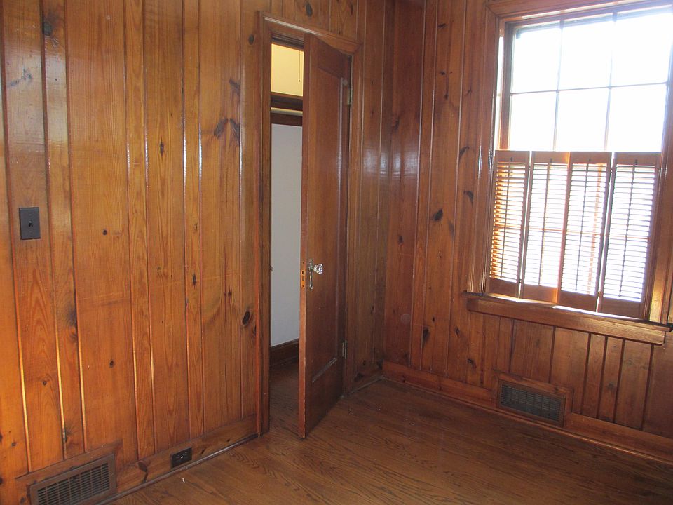 Left side of Study showing closet with built-in shelves. Very narrow doorway. View of magnolia tree and tall holly hedge and back driveway.