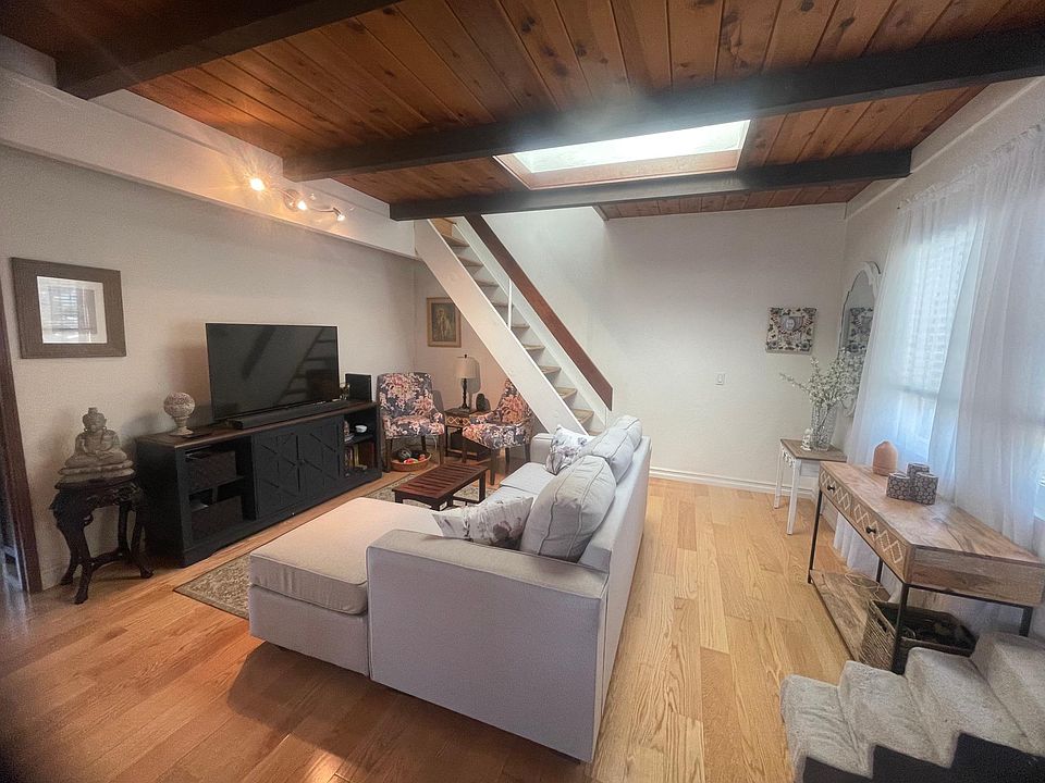 Living area with skylight and view of stairs to loft.
