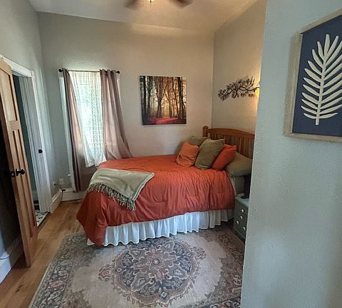 Main bedroom with attached bath, TV mounted on wall, ceiling fan for comfort.
