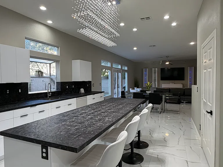 Kitchen island seating accented by a contemporary crystal chandelier and open-concept flow.