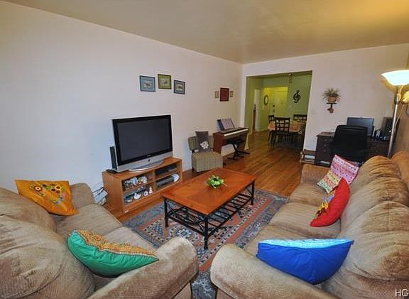 Large Bright living room with hardwood floors opens to the large dining foyer.