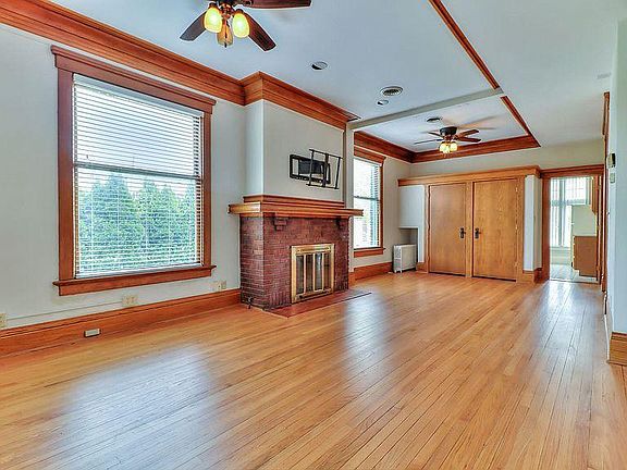 Living space and dining area with working fireplace, hardwood floors and oak trim.