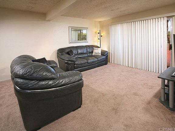 The spacious living room is drenched in natural li