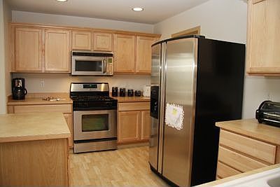 Well designed kitchen with maple cabinets and stainless steel appliances