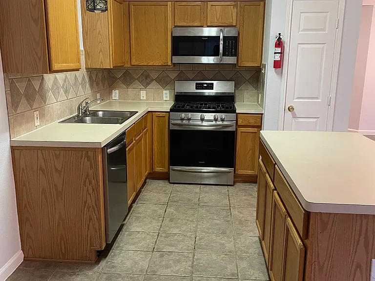 Kitchen with new stainless steel appliances (dishwasher, stove and microwave)