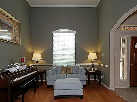 Formal living room has custom paint, hardwoods, crown molding and chair rail m