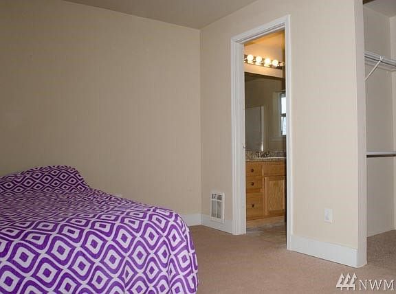 Master bedroom with view to walk-in-closet and attached 3/4 bath.