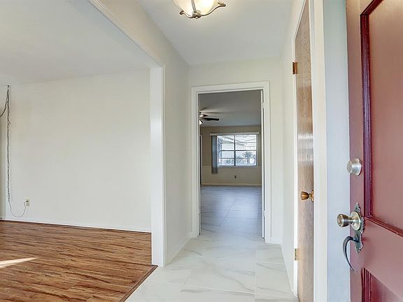 Step into your new foyer with beautiful tile floors, neutral paint, a gorgeous light fixture, and a convenient coat closet.