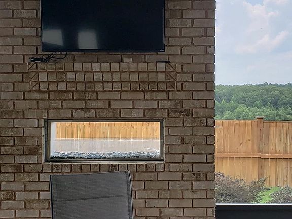 Back patio fireplace with mounted television