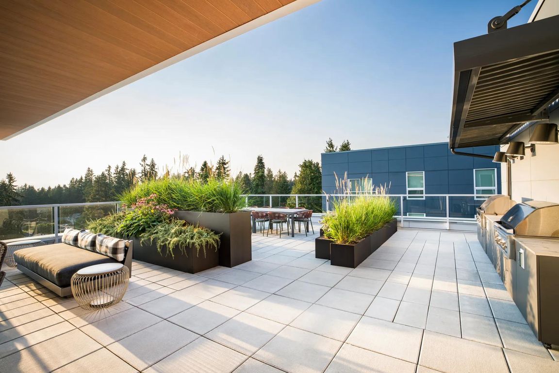 Enjoy open-air dining and grilling with a view on Modera Shoreline's rooftop terrace_perfect for weekend gatherings or quiet evenings above the trees.