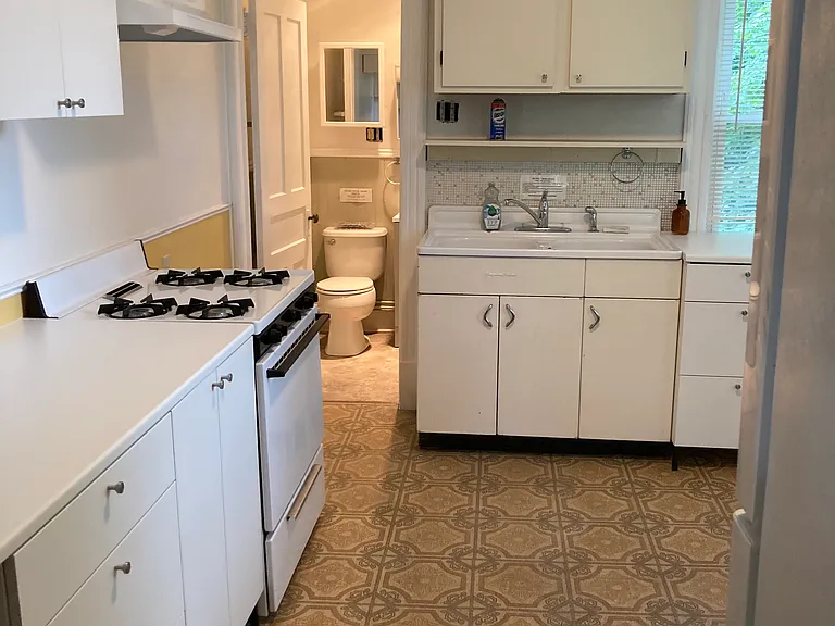 Kitchen with a mix of newer cabinets and vintage cast iron porcelain sink.