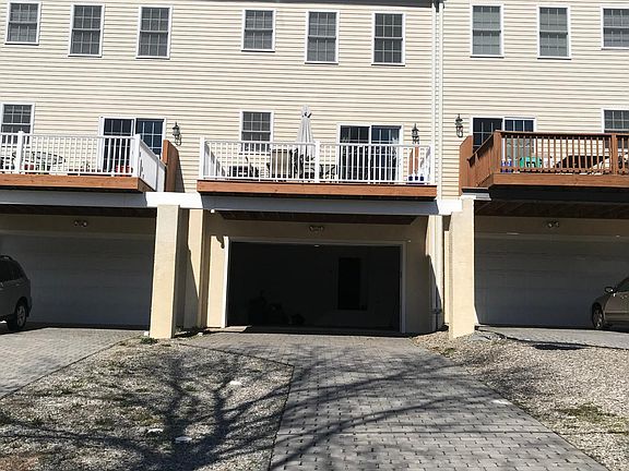 Rear exterior with 2 car garage and lots of parking