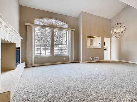 Large living room with fireplace, dining room area which can accommodate a large dining table. Window view faces the golf course.