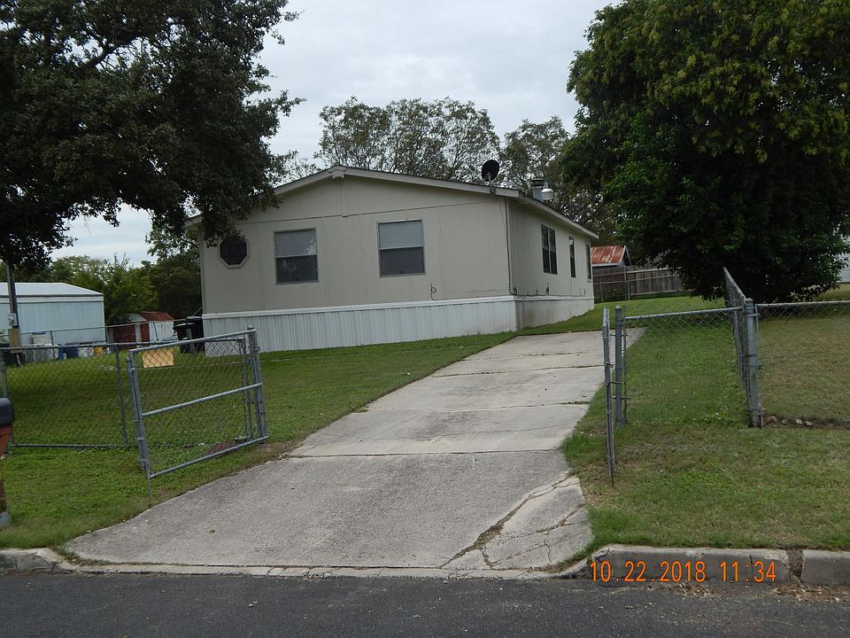 Looking from street showing driveway, front of home and front fence with gates open.