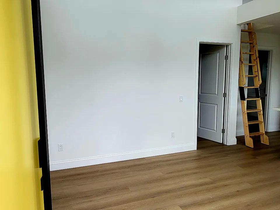 Living room. Door on right is the bedroom. Ladder to the right is to the loft that has a low ceiling.